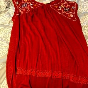 Red tank top and decorated in the top where the neckline is